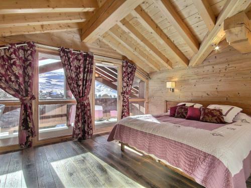 une chambre avec un lit dans une pièce avec des fenêtres dans l'établissement Magnifique appartement haut de gamme avec cheminée et parkings couverts - FR-1-455-228, à La Plagne Tarentaise