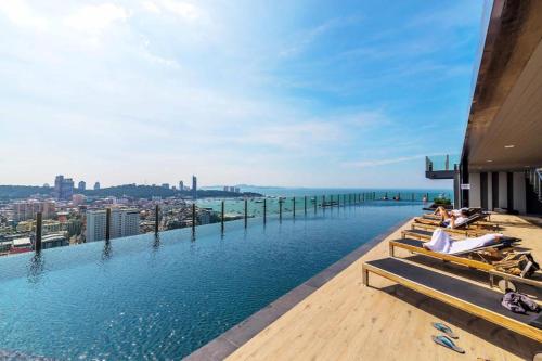 a infinity pool with a view of the city at 芭提雅双人精品公寓无边游泳池THEBASE中央基地 in Pattaya