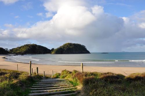 a stairway leading down to a beach with two islands at Matapouri & Tutukaka Spectacular Coastal Views- Aroha Luxury Guest Suite in Tutukaka