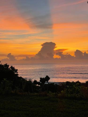 a sunset on the beach with the ocean in the background at Taitung Blue Sea Villa in Chenggong