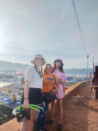 Três mulheres posam para uma foto numa marina. em SUN'S TRAVEL AND TOURS AGENCY CORON PALAWAN em Coron