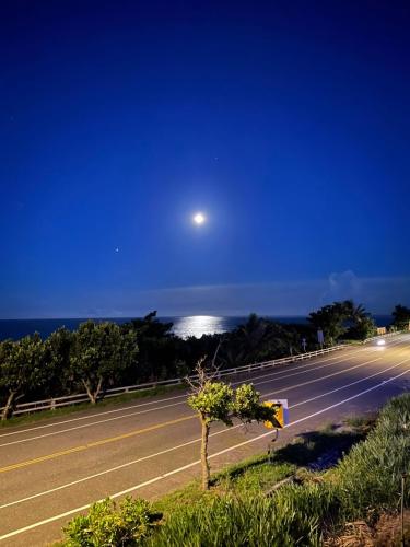 an empty road at night with a moon in the sky at Taitung Blue Sea Villa in Chenggong