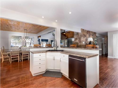 a kitchen with white cabinets and a dining room at Cozy Escape, Kawarthas Cottage With Sauna in Buckhorn
