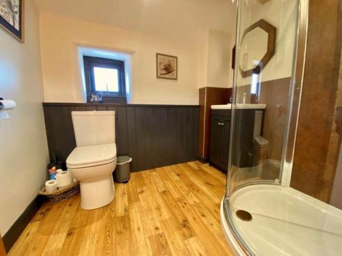 a bathroom with a toilet and a shower at Stylish & cosy barn minutes from the Lake District in Penrith