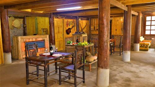 une salle à manger avec une table, des chaises et une cheminée dans l'établissement H'mong Eco House, à Lào Cai