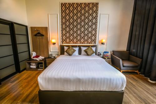 a hotel room with a large bed and a chair at Woda Villa & Spa in Sengkuang