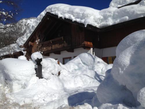 a house covered in snow in front of it at Aqua Apartments Spa Housemuhlbach in Sappada