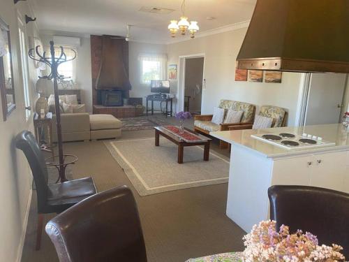 a kitchen and living room with a stove top oven at Daisy Cottage located on Buckland Estate in Irishtown
