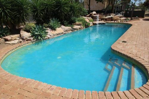 a large blue pool with a brick walkway at Daisy Cottage located on Buckland Estate in Irishtown