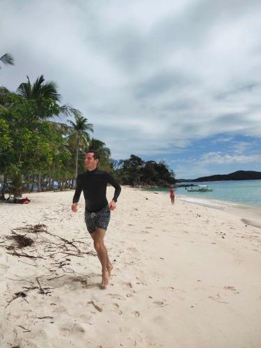 Un homme court sur la plage dans l'établissement SUN'STAR TRAVEL AND TOURS AGENCY CORON PALAWAN, à Coron