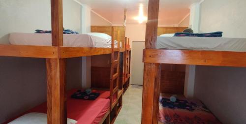 a room with three bunk beds in a room at Mandurah's Inn, Malapascua in Malapascua Island