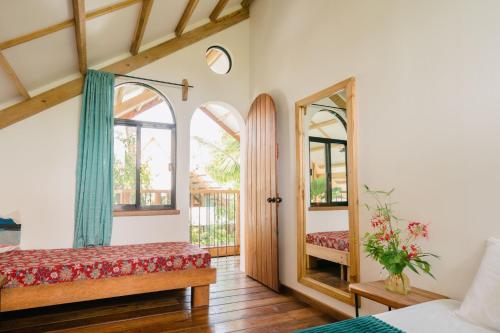 Schlafzimmer mit einem Bett und einem Spiegel in der Unterkunft Hygge Siargao in General Luna