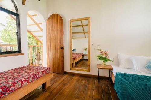 a bedroom with a bed and a mirror and a table at Hygge Siargao in General Luna