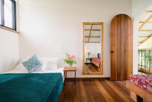 a bedroom with a bed and a mirror and a door at Hygge Siargao in General Luna
