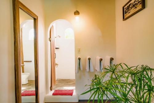 a hallway with a bathroom with a shower and a mirror at Hygge Siargao in General Luna