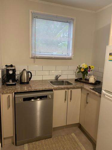 a kitchen with a sink and a dishwasher at Mission Retreat in Kerikeri