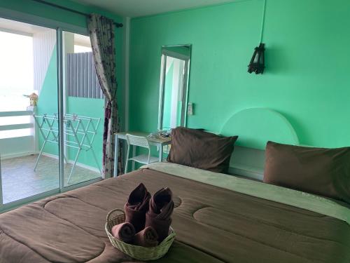 ein Schlafzimmer mit grünen Wänden und einem Bett mit Schuhen drauf in der Unterkunft วินเนอร์วิว เกาะล้าน in Ko Larn