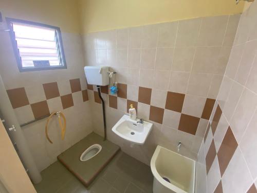 ein kleines Bad mit einem Waschbecken und einem WC in der Unterkunft Homestay Cikgu Muaz in Kuala Kangsar