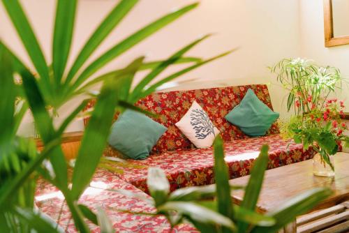 a red couch with pillows and a table with plants at Hygge Siargao in General Luna