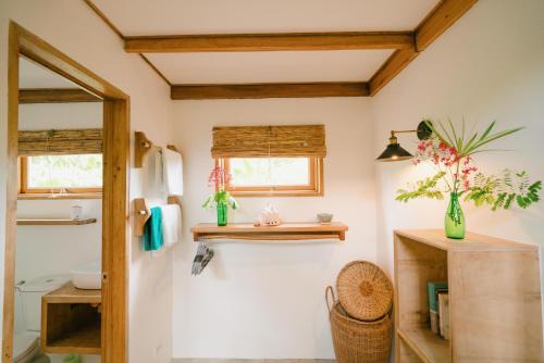 a bathroom with white walls and wooden ceilings at Hygge Siargao in General Luna