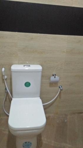 a white toilet in a bathroom with a roll of toilet paper at Ocean Dream in Tangalle
