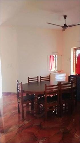 - une salle à manger avec une table et des chaises en bois dans l'établissement Texas guest house 4 bed Rooms, à Chalai