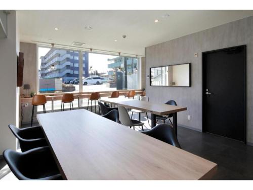 Megu fuji 2021 - Vacation STAY 74533v في فوجيوشيدا: غرفة طعام بها طاولات وكراسي ونافذة كبيرة