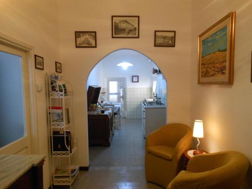 a living room with an archway and a living room with a chair at B&B Le Stanze del Chiostro in Serra deʼ Conti