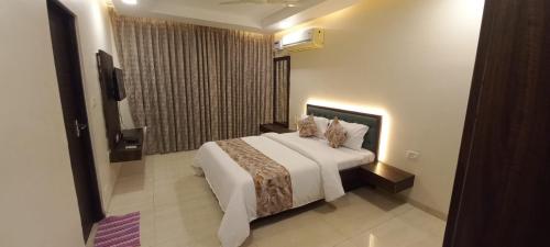 een slaapkamer met een groot wit bed en een raam bij Nishka holiday home in Candolim