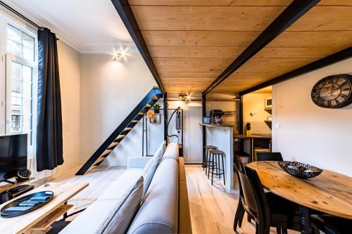 un salon avec un canapé et une table en bois dans l'établissement Le Château Senard, Studio cosy 23 m2 au calme proche gare - 3 min, à Rouen