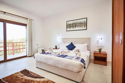 a bedroom with a large bed and a balcony at Malika Nungwi Hotel in Nungwi