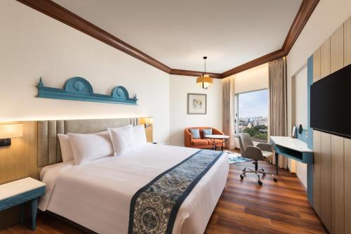 a hotel room with a bed and a desk at Welcomhotel by ITC Hotels, Devee Grand Bay, Visakhapatnam in Visakhapatnam