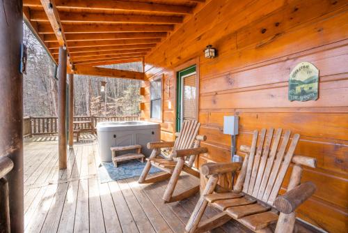 two rocking chairs on the porch of a cabin at Moonshine Ridge Cabin with Hot Tub and Fire Pit in Pigeon Forge