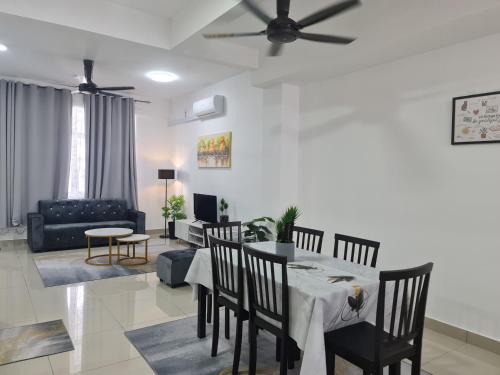 Madinatus Syifa Homestay في كوتا تينجي: غرفة معيشة مع طاولة وكراسي وأريكة