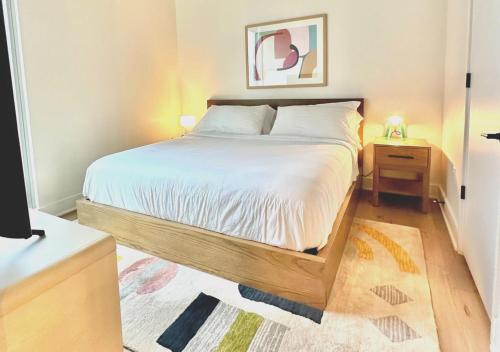 um quarto com uma cama grande e uma estrutura em madeira em Brand New - Spacious Luxury Condo, Steps from Lake & Rainey for 4 em Austin