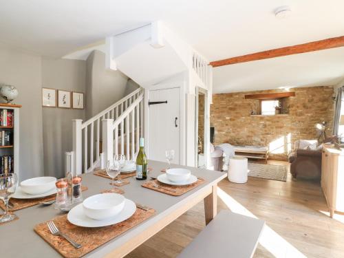 a dining room with a table with plates and wine glasses at The Tap Room in Kingham