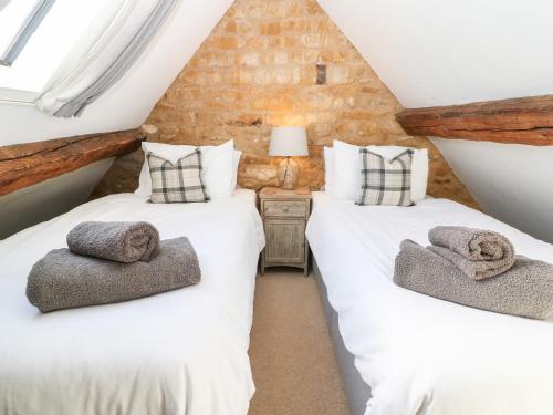 two twin beds in a attic bedroom in a house at The Tap Room in Kingham