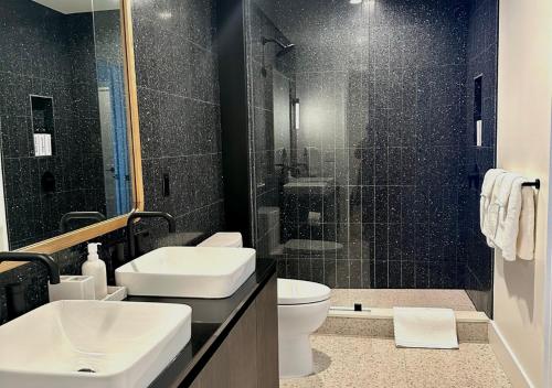 ein Bad mit einem Waschbecken, einem WC und einer Dusche in der Unterkunft Brand New - Spacious Luxury Condo, Steps from Lake & Rainey for 4 in Austin