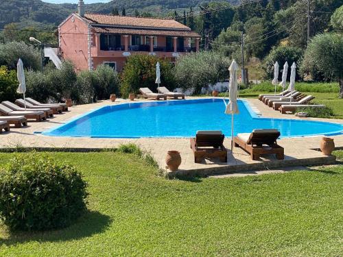 a large swimming pool with lounge chairs and umbrellas at Stefanos Resort in Mesongi