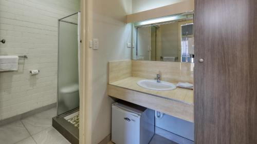 ein Bad mit einem Waschbecken und einer Dusche in der Unterkunft Rose City Motor Inn in Benalla
