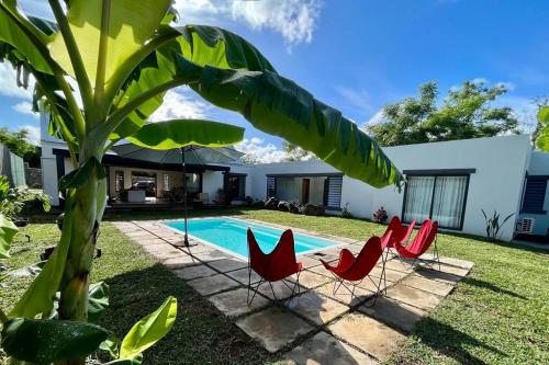 a yard with chairs and a swimming pool at 3 bedroom villa nestled in nature in Rivière Noire