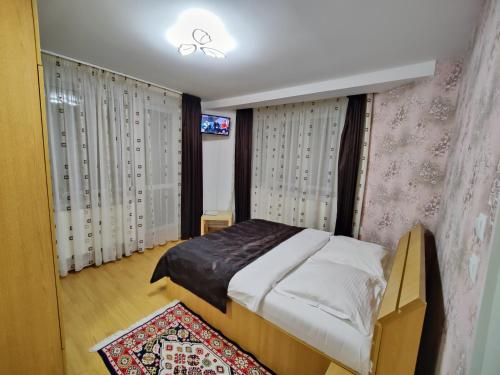 1 dormitorio con 1 cama y TV. en Casa Adina, en Sinaia