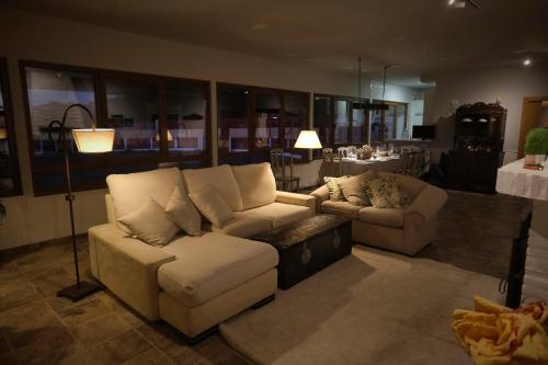 a living room with a couch and a chair at CASA RURAL "LA MAZA" entre encinas y dehesas in Terradillos
