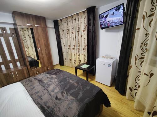 a bedroom with a bed and a tv on the wall at Casa Adina in Sinaia