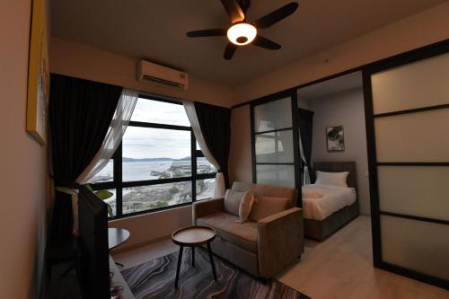 ein Schlafzimmer mit einem Sofa, einem Bett und einem Fenster in der Unterkunft Kota Kinabalu Jesselton Quay Sea View with washing machine in Kota Kinabalu