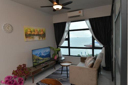 a living room with a couch and a large window at Kota Kinabalu Jesselton Quay Sea View with washing machine in Kota Kinabalu
