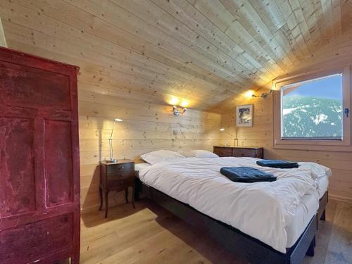 - une chambre avec un grand lit dans une cabane en bois dans l'établissement Les Granges de Sarreyer, à Sarreyer