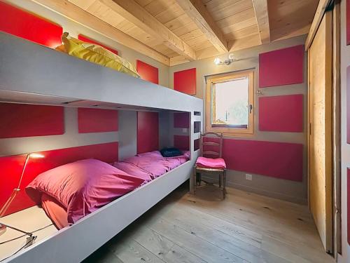 a bedroom with a bunk bed with a red wall at Les Granges de Sarreyer in Sarreyer