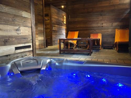 a jacuzzi tub in a room with chairs at Les Granges de Sarreyer in Sarreyer