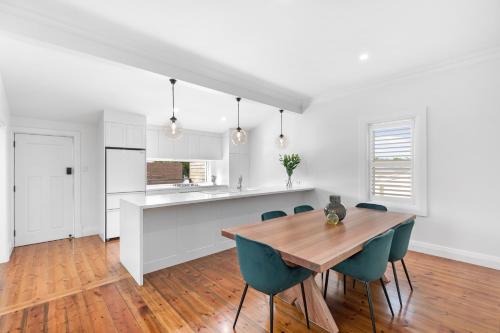 a kitchen and dining room with a wooden table and chairs at Luxury Cottage Accommodation in Mount Gambier